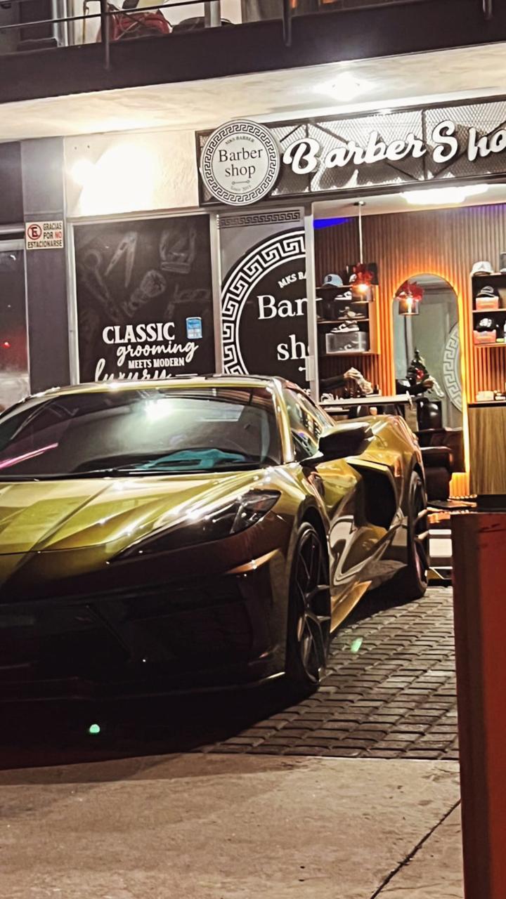 Exterior de Mike's Barber con automóvil frente a la barbería
